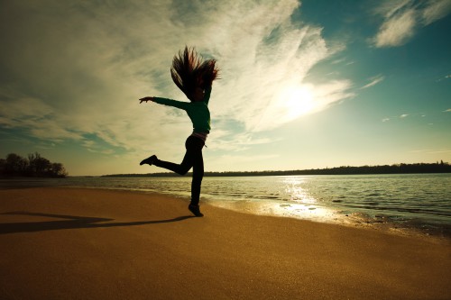 Woman Jumping On The Beach On Sunny Sky Background, Freedom And