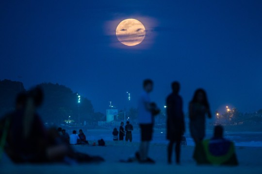 The full moon, nicknamed "the supermoon", rises at Ipanema beach in Rio de Janeiro, Brazil, on August 10, 2014. A supermoon is the coincidence of a full moon or a new moon with the closest approach the Moon makes to the Earth on its elliptical orbit, resulting in the largest apparent size of the lunar disk as seen from Earth. AFP PHOTO / YASUYOSHI CHIBA